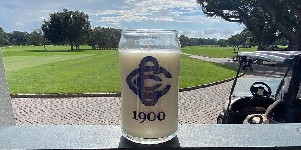 Glass of 1900 beer with a golf course in the background