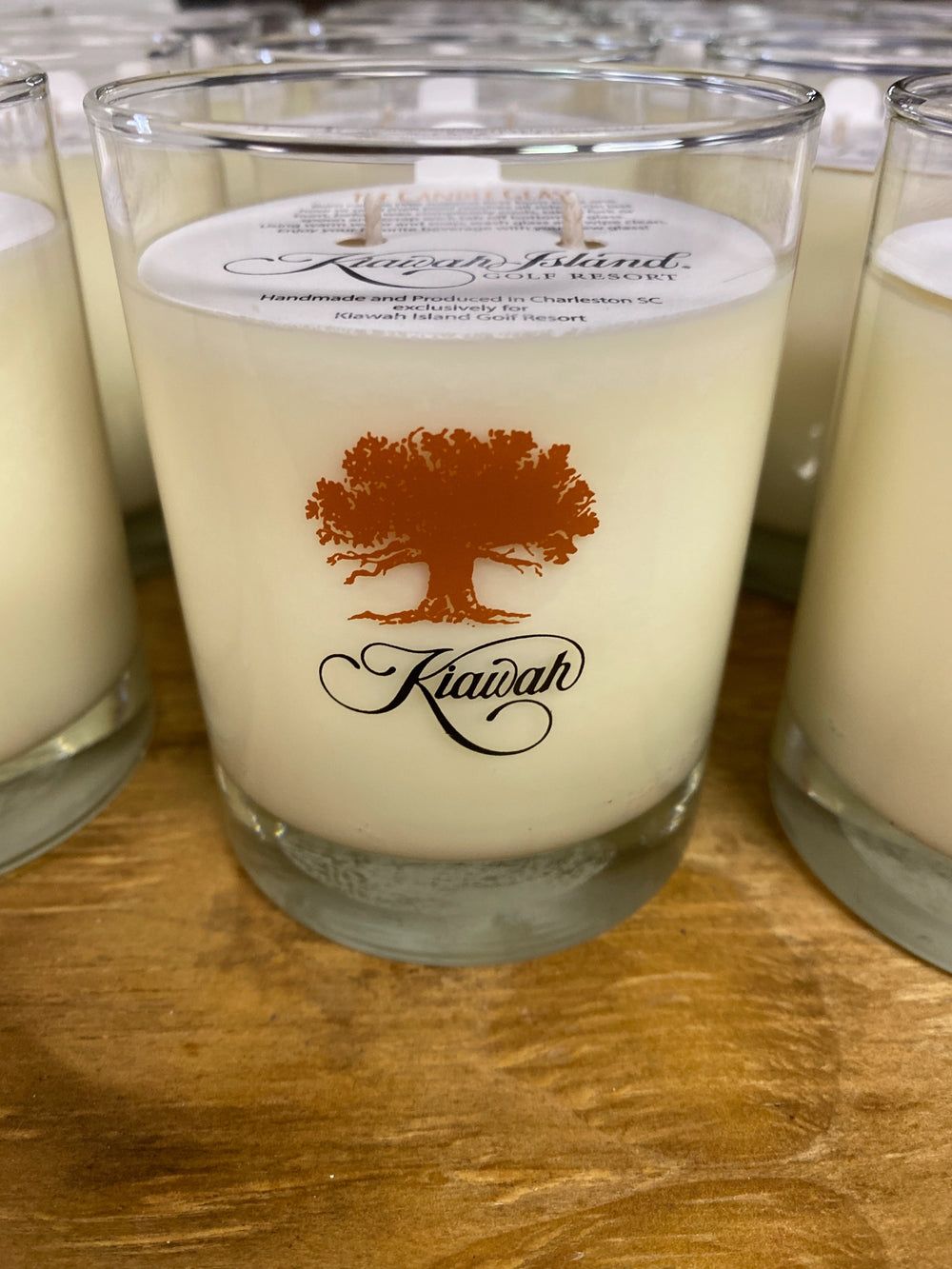Glass candle with Kiawah Island logo on a wooden surface