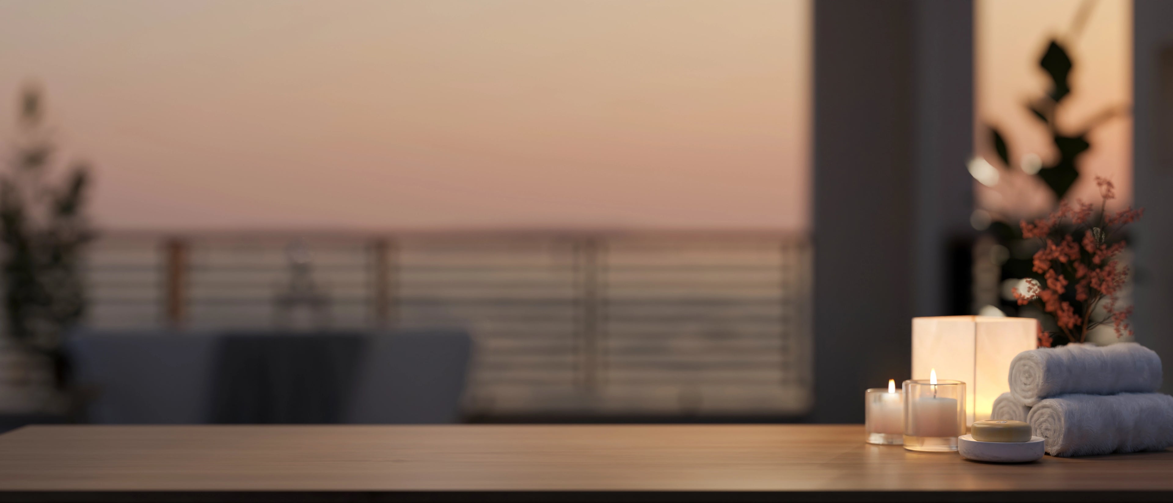 Candlelit table setting with candles and towels in a blurred room background