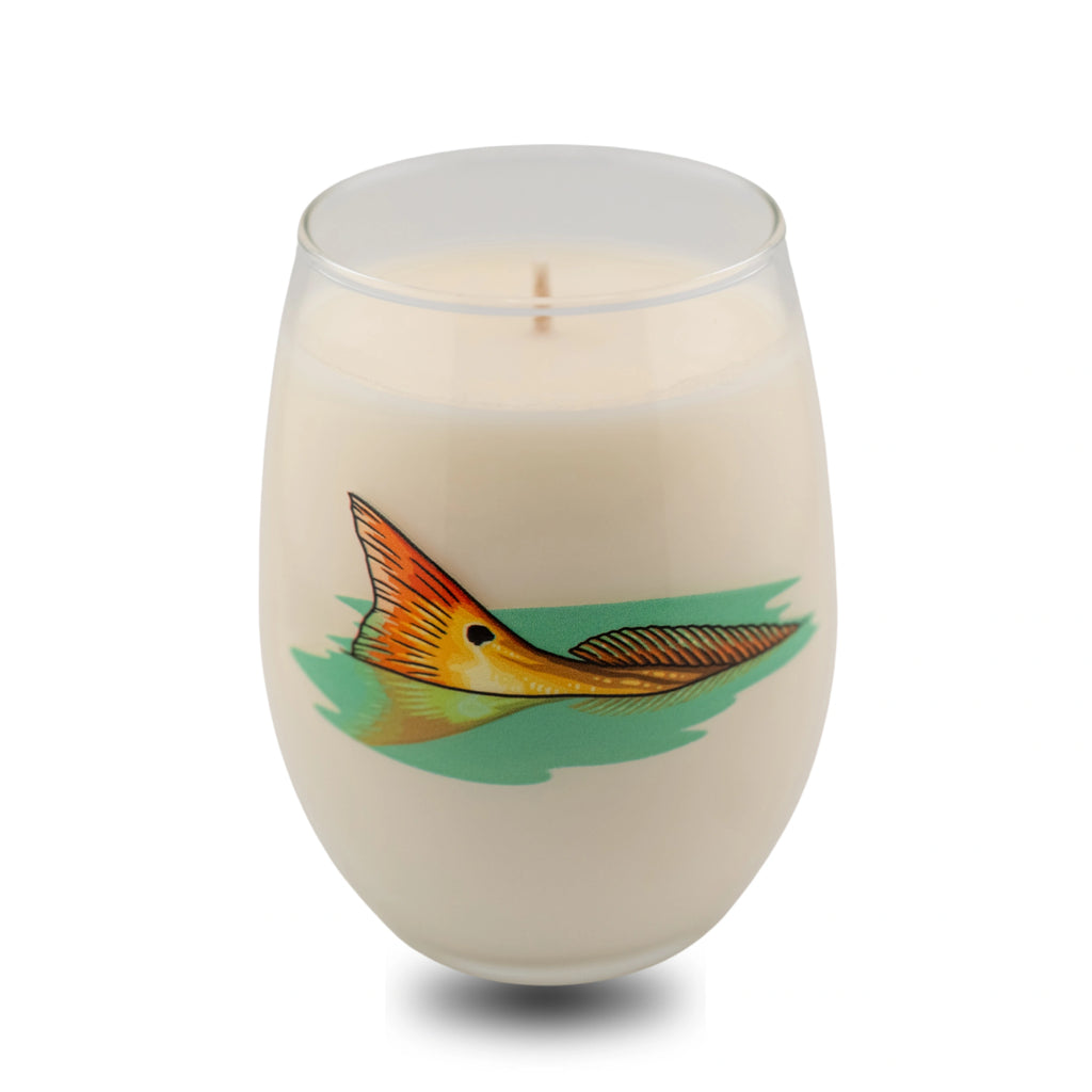 Candle in a glass container with a fish design on a white background