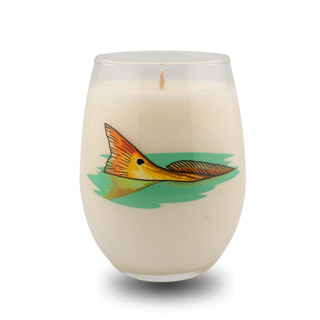 Candle in a glass container with a fish design on a white background