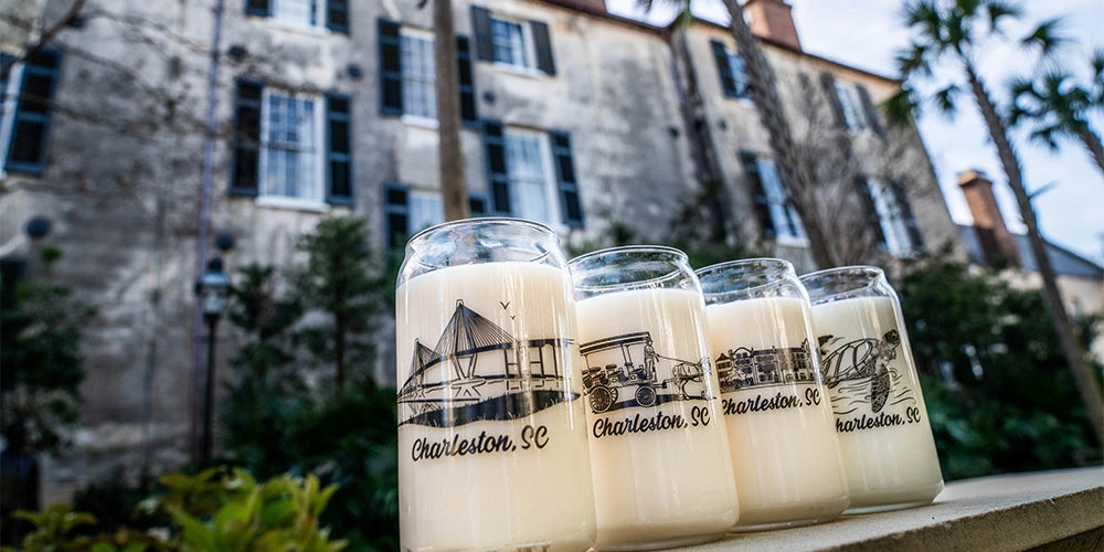 Set of milk jars with 'Charleston, SC' branding in front of a historic building.
