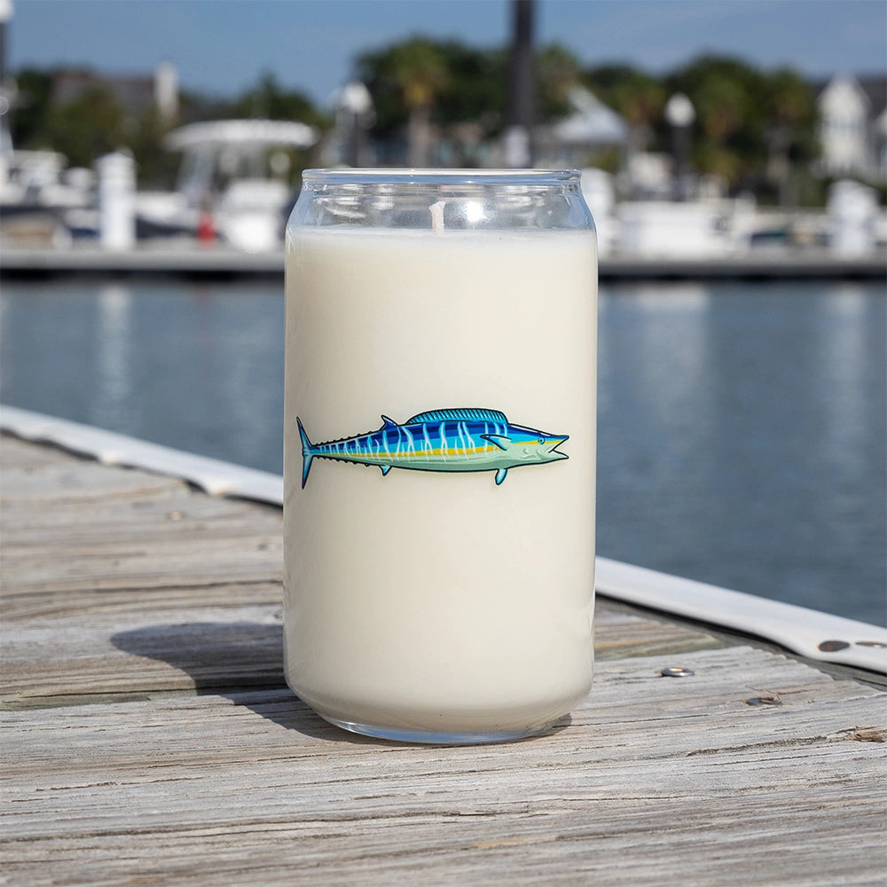 Glass of milk with a fish illustration on a dock by a marina