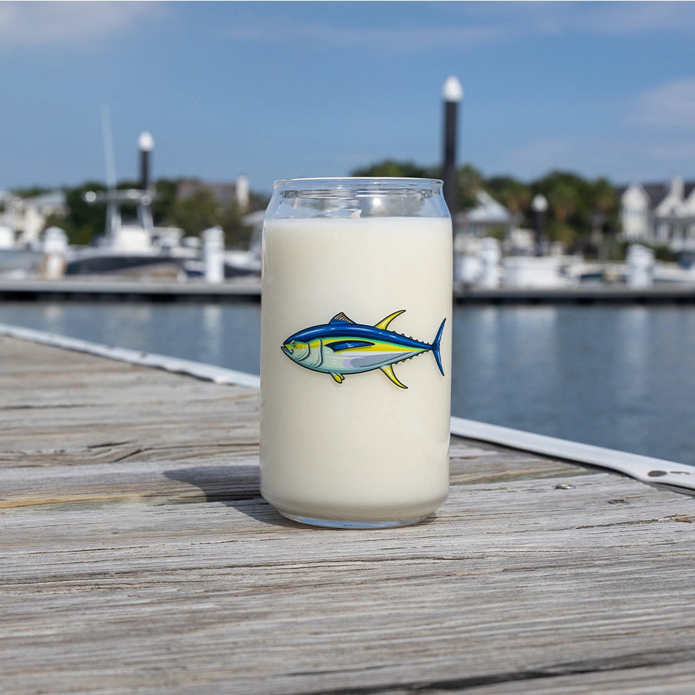 Glass with a fish design on a wooden dock by a marina